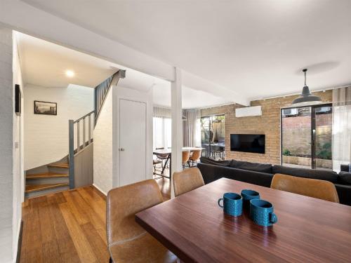 a dining room and living room with a table and chairs at Cosy Corner Town Centre in Margaret River Town