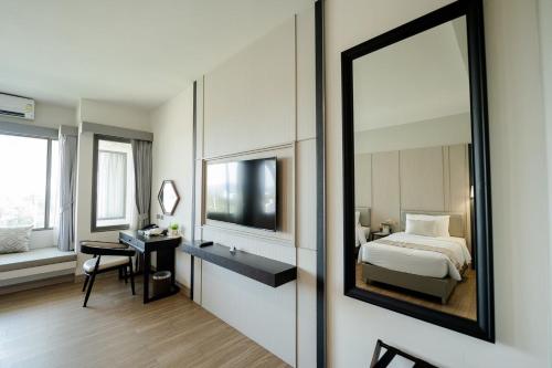 a hotel room with a bed and a mirror at THE NAVY HOUSE HOTEL in Sattahip