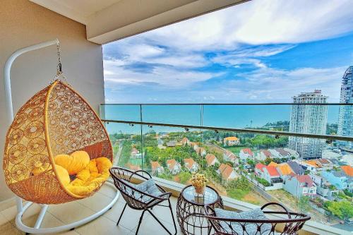 a room with a balcony with chairs and a swing at T- HOLYDAY THESONG APARTMENT - Căn Hộ Nghỉ Dưỡng Cao Cấp Gần Biển Thành Phố Vũng Tàu in Vung Tau