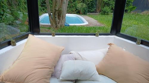 Un sofá blanco con dos almohadas frente a una ventana. en Casa San Isidro, en San Isidro