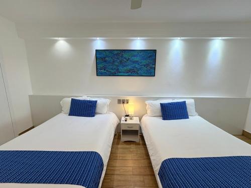 two beds in a small room with blue and white at Cancun Plaza - Best Beach in Cancún