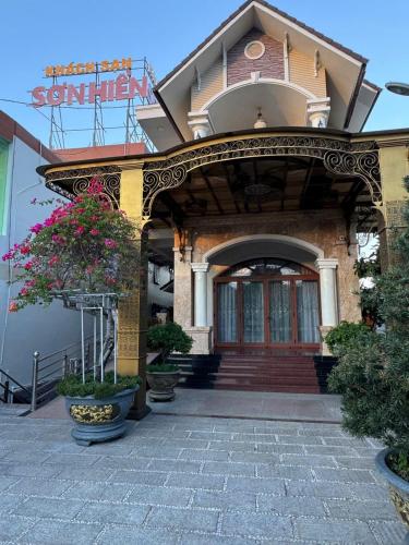 an entrance to a building with flowers in front of it at Khách Sạn Sơn Hiển in Cam Lâm
