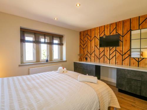 a bedroom with a bed with a tv on a wall at Cherry Tree Farm in Chesterfield