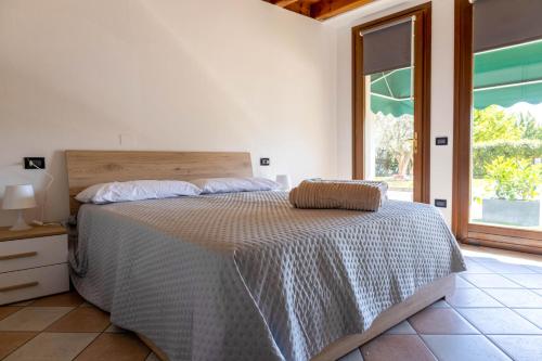 a bedroom with a bed and a large window at Ca' Linda By Case al Lago in Desenzano del Garda
