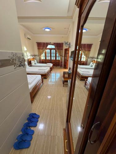 a room with three beds and blue bowls on the floor at Khách Sạn Sơn Hiển in Cam Lâm