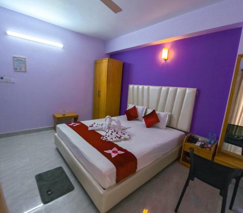 a bedroom with a large bed with purple walls at Hotel Ruponti in Kuākāta