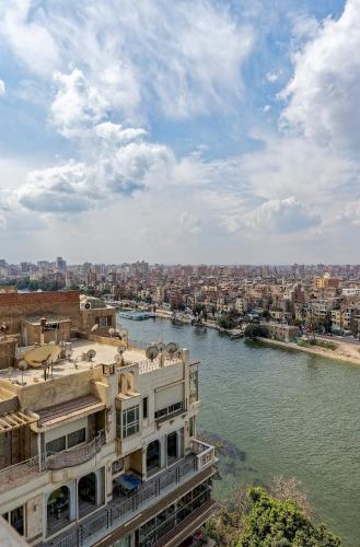 a building next to a river with buildings at VESTA - Nile Zamalek Residence in Cairo