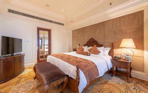 a bedroom with a large bed and a flat screen tv at Zhengzhou Yiquan International Hotel in Zhengzhou