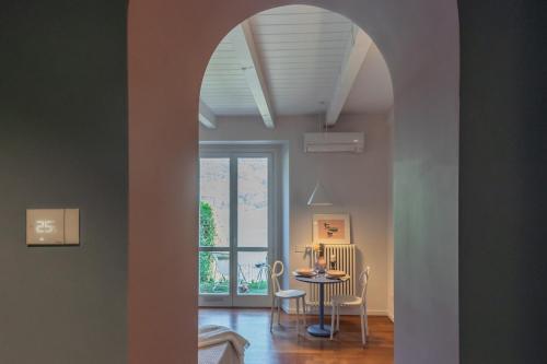 a dining room with an archway and a table and chairs at OC Lake Love by Rent All Como in Laglio