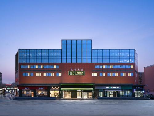 a large building with many windows in a parking lot at Baiman Hotel Beijing South Railway Station Heyi Subway Station Branch in Beijing