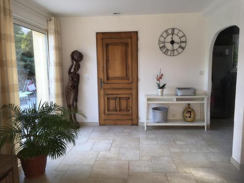 une pièce avec une porte et une horloge sur le mur dans l'établissement - 30 pour cent semaine du 19 juillet Villa 12 p entre Nice et Cannes piscine clim, à Roquefort-les-Pins