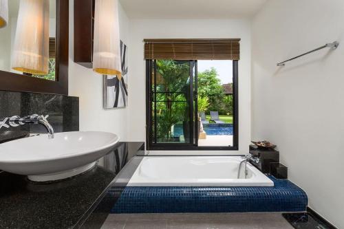 a bathroom with a white tub and a sink at Villa Haeata | Gorgeous 3 bedroom villa in the secured residence in Nai Harn Beach