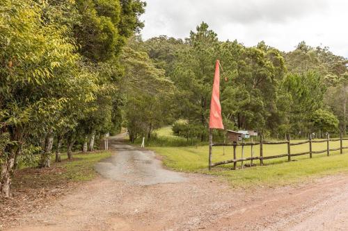 a dirt road with a red flag on a fence at Ocean views Close to Coolum Pet friendly Firepit Mountain Views in Yandina Creek
