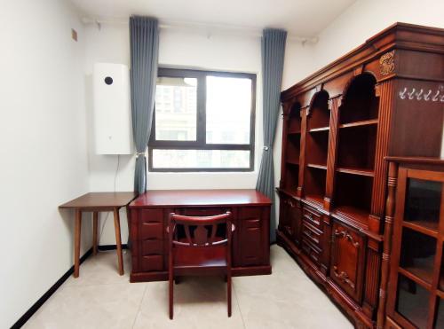 a room with a wooden desk and a window at Ivy Residence in Jiaozhou
