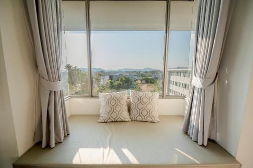 a window seat with a pillow in front of a window at THE NAVY HOUSE HOTEL in Sattahip