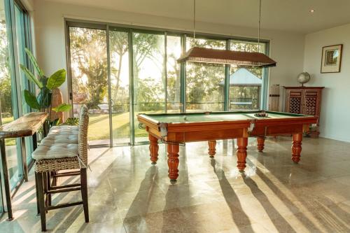 a pool table in a living room with windows at Ocean views Close to Coolum Pet friendly Firepit Mountain Views in Yandina Creek