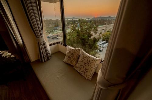 a room with a couch in front of a large window at THE NAVY HOUSE HOTEL in Sattahip