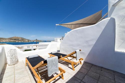 a rooftop deck with chairs and tables on a house at Yades Suites & Spa - Adults only in Naousa
