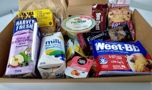 una scatola piena di diversi tipi di cibo e snack di Busselton Motel a Busselton