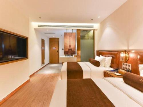 a hotel room with two beds and a flat screen tv at James Joyce Coffetel Shijiazhuang the Mixc Jinyuan Tower Airport Bus in Shijiazhuang