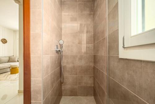 a bathroom with a shower with a shower head at Eclectic Blue Apartment on Sheinkin by Sea N' Rent in Tel Aviv