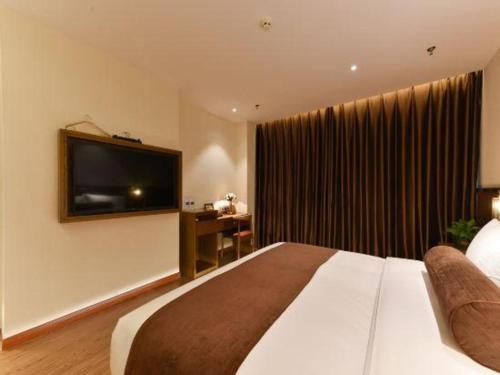 a hotel room with a large bed and a flat screen tv at James Joyce Coffetel Shijiazhuang the Mixc Jinyuan Tower Airport Bus in Shijiazhuang