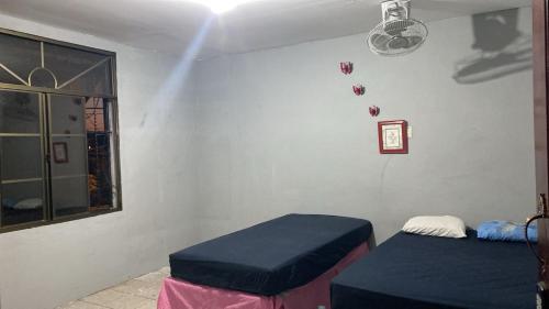 a room with two twin beds and a window at Lirio green hostal in Managua