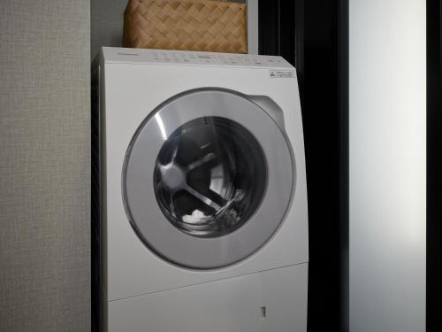 a washing machine with a silver door in a room at Premium Apart MONday KYOTO GOJO in Kyoto