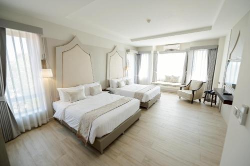 a hotel room with two beds and a television at THE NAVY HOUSE HOTEL in Sattahip