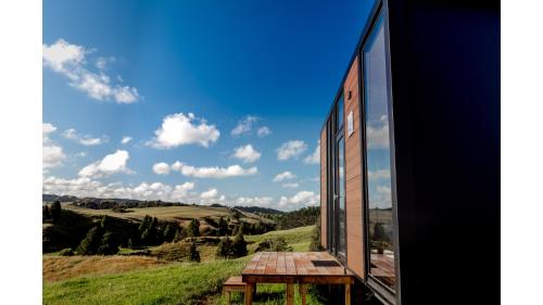 una finestra con vista sulle montagne da una casa di Mighty Tiny House 2 by Tiny Away a Ruawaro