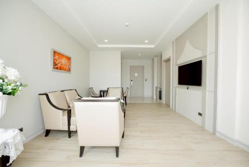 a dining room with white walls and a table and chairs at THE NAVY HOUSE HOTEL in Sattahip
