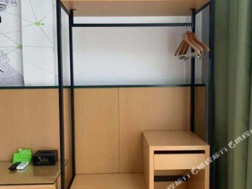a shower stall in a room with a table at Vatica Hotel Hefei Yaohai Longgang Subway Station in Hefei