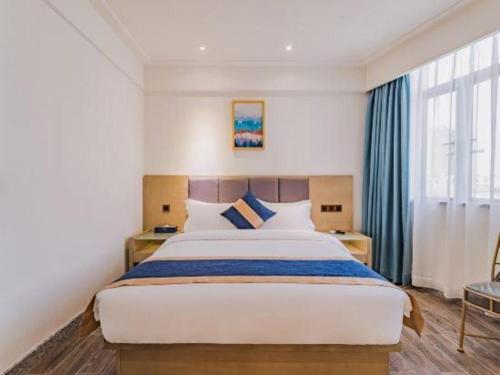 a bedroom with a large bed and a large window at Borrman Hotel Huizhou West Lake Shuidong Street in Huizhou