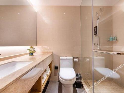 a bathroom with a toilet and a tub and a sink at City Comfort Inn Kunshan High-speed Railway Station Renmin Road in Suzhou