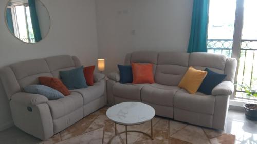 a living room with a couch with colorful pillows at 4K-Suite in Kingston