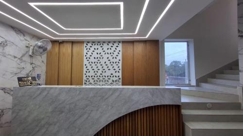 a lobby with a staircase and a window and a ceiling at Hotel Ruponti in Kuākāta