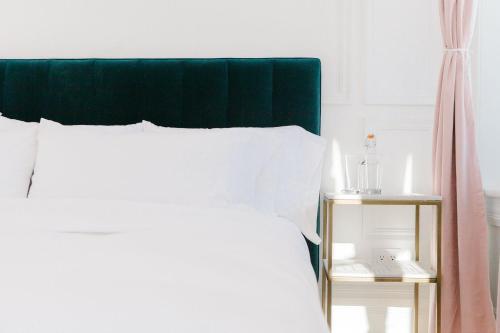 a bed with a green headboard and a side table at The Wyman Hotel in Silverton