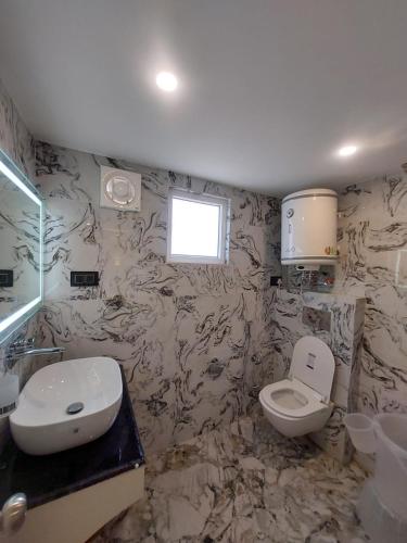 une salle de bain avec toilettes et lavabo dans l'établissement HOTEL SUNLIGHT SRiNAGAR, à Srinagar
