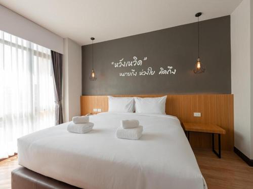 une chambre avec un grand lit blanc avec deux oreillers dans l'établissement B2 Surat Thani Premier Hotel, à Surat Thani