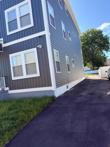 a house with a driveway next to a building at Excel homes in East Orange