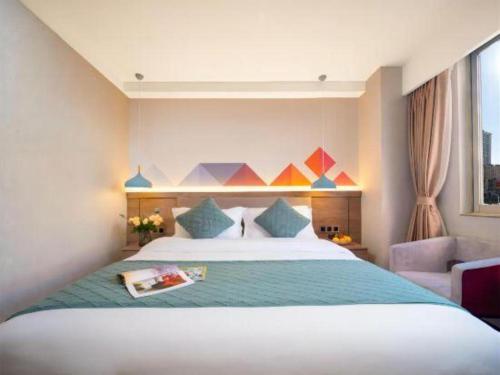 a hotel room with a large bed and a couch at Borrman Hotel Yuxi Yuxing Road in Yuxi