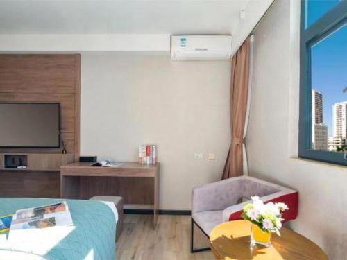 a hotel room with a bed and a tv at Borrman Hotel Yuxi Yuxing Road in Yuxi