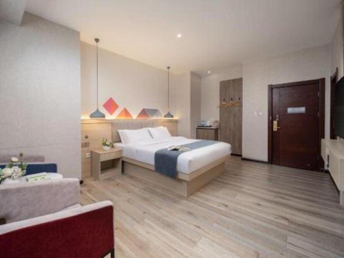 a bedroom with a bed and a couch in a room at Borrman Hotel Yuxi Yuxing Road in Yuxi