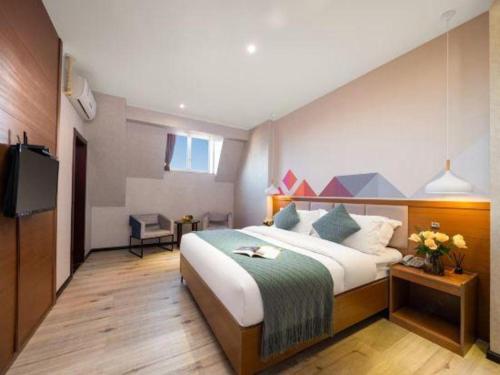 a hotel room with a bed and a television at Borrman Hotel Yuxi Yuxing Road in Yuxi