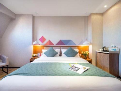 a bedroom with a large bed with a colorful headboard at Borrman Hotel Yuxi Yuxing Road in Yuxi