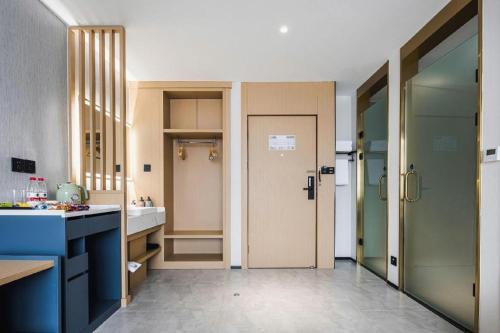 a kitchen with a sink and a door to a bathroom at GEM Hotel Changzhou Xuejia'aoyuan North High-Speed Railway Station in Changzhou