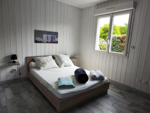 - une chambre avec un lit, des serviettes et une fenêtre dans l'établissement Maison Papillon piscine couverte, à Grayan-et-lʼHôpital