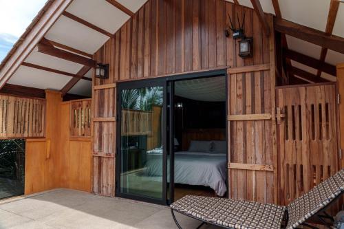 Un edificio de madera con una cama en un dormitorio. en Thammachard29 Resort Baangrood, en Thong Chai