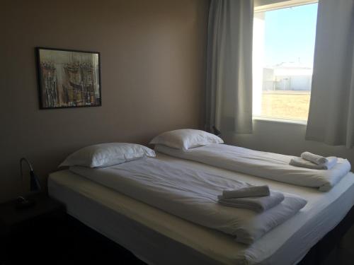 two beds in a room with a window at North Star Apartments Rif in Snæfellsbær