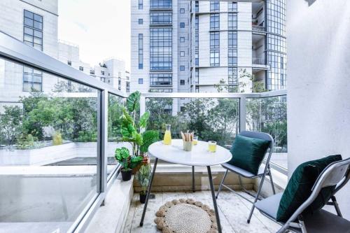 un balcone con tavolo e sedie e vista sulla città di Charming 1BR Apt w Balcony In the Heart of TLV with Mamad by Sea N' Rent a Tel Aviv
